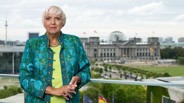 Kulturstaatsministerin Claudia Roth auf der Terrasse des Bundeskanzleramts; im Hintergrund ist der Reichstag zu sehen.