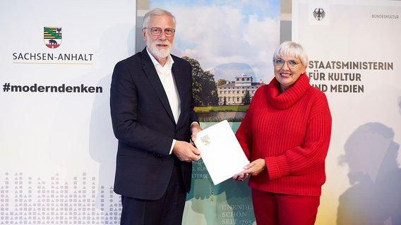 Kulturstaatsministerin Roth und Sachsen-Anhalts Kulturminister Robra halten die unterzeichnete Verwaltungsvereinbarung über die gemeinsame Finanzierung des Masterplans Bau- und Gartendenkmalpflege der Kulturstiftung Dessau-Wörlitz in die Kameras.