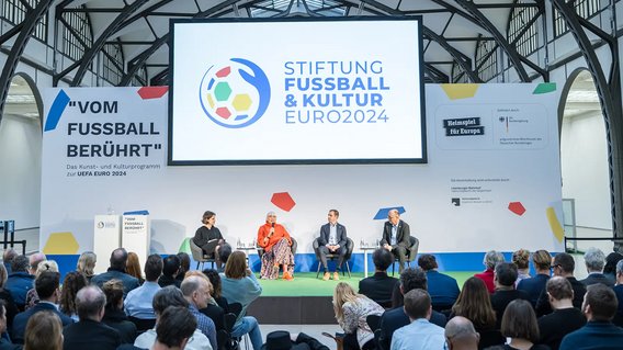 Claudia Roth, Juliane Seifert, Phlipp Lahm und Bernhard Gutowski auf der Bühne bei der Vorstellung des Kulturprogramms zur UEFA EURO 2024