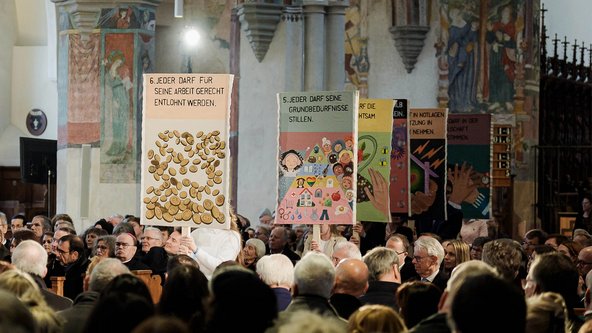 Mittels Plakaten präsentieren Schülerinnen und Schülern der Memminger Lindenschule beim Festakt ihre eigene Interpretation der Zwölf Artikel.