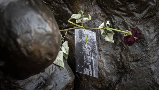 Eine Fotografie, angebracht am Denkmal des Warschauer Aufstands, zeigt einen jungen Widerstandskämpfer. Eine rote Rose wurde zum Gedenken an den Kämpfenden angebracht.