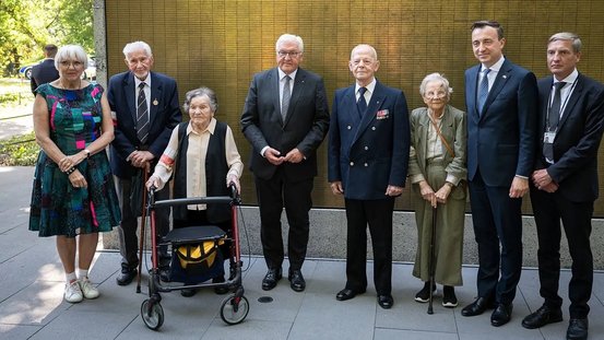 Gruppenfoto zeigt Kulturstaatsministerin Roth und Bundespräsident Steinmeier bei einem Treffen mit Zeitzeuginnen und -zeugen des Warschauer Aufstandes.