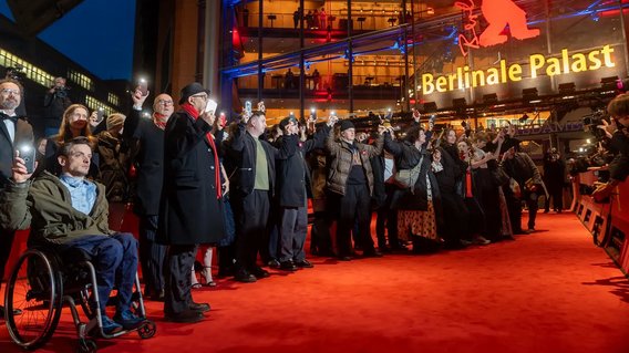 Schauspielerinnen und Schauspieler und die Berlinaleleitung protestieren auf dem roten Teppich