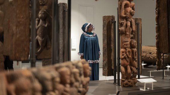 Das Bild zeigt eine Frau, die sich die Ausstellung im Humboldt Forum ansieht.